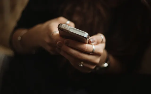 Persona conversando por WhatsApp en su celular